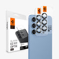 AGL09090 - Galaxy S25 Optik Pro EZ Fit Lens Protector in Black showing 2 lens protector hovering in front of the device with the packaging behind it